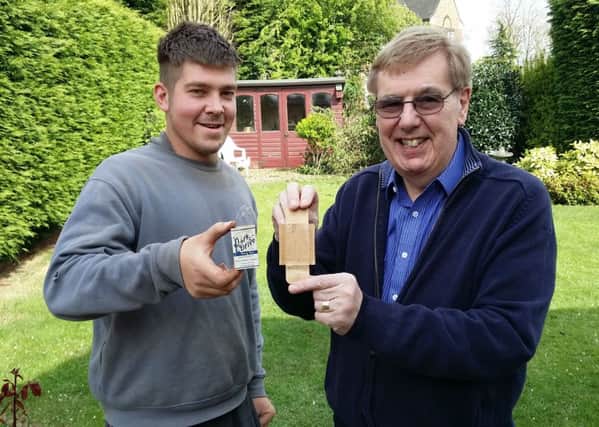 Builder Jake Burdett and Richard Sage hold a cigarette packet with was written on by builders in 1939 and left in the brickwork before being found by Jake EMN-170205-104550001