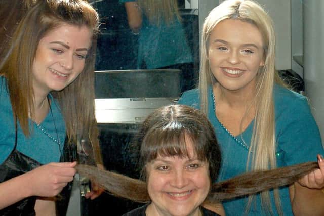 Hairdressing students from Brooksby Melton College, Michelle Barrett and Lauren Coy, help tutor Jo Sloan with her charity hair-cutting effort EMN-171205-121812001