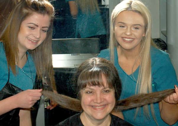 Hairdressing students from Brooksby Melton College, Michelle Barrett and Lauren Coy, help tutor Jo Sloan with her charity hair-cutting effort EMN-171205-121812001