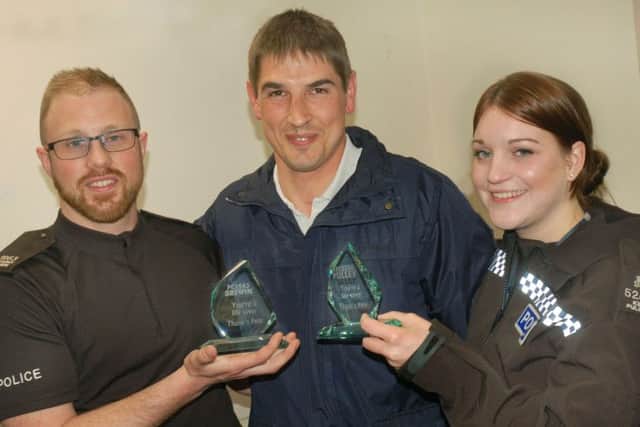 Peter Pope presents awards to Melton police officers PC Anthony Brewin and SPC Kimberly Pulley after they came to his aid when he was hit by a car in the town EMN-170516-102600001