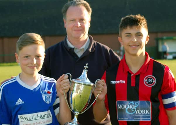 Secretary of Melton and District Charity Cup Committee Alan Digby with Sileby captain Luke Barratt on the left, and Ben Marshall from Barrow EMN-170516-180154002