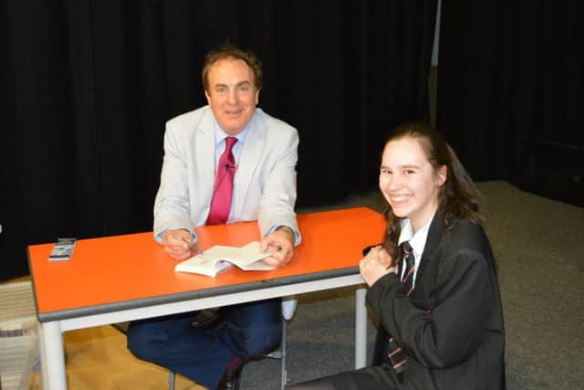 John signs one of his books PHOTO: Supplied