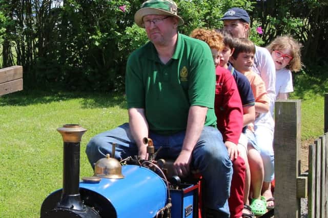 John Seagrave driving 'Lilla' - a 7 1/4" gauge model Hunslet quarry locomotive with a group of happy passengers across the level crossing of the society's track towards 'Little Whissendine' station PHOTO: Supplied
