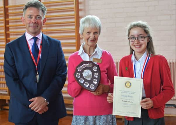 Izabella receives her trophy, medal and certificates from Maggie Saunders and Brownlow headteacher Damien Turrell PHOTO: Supplied