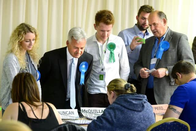 656464-12 : Â©Lionel Heap : News : Rutland & Melton Parliamentary Election Count 2017 : Candidates and their agents watch the count. Sir Alan Duncan (Conservative) and Alastair McQuillan (Green Party) (centre). EMN-170613-182918001