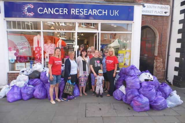 Melton Slimming World members, consultants and Cancer Research UK shop representatives with donated bags of clothes PHOTO: Supplied