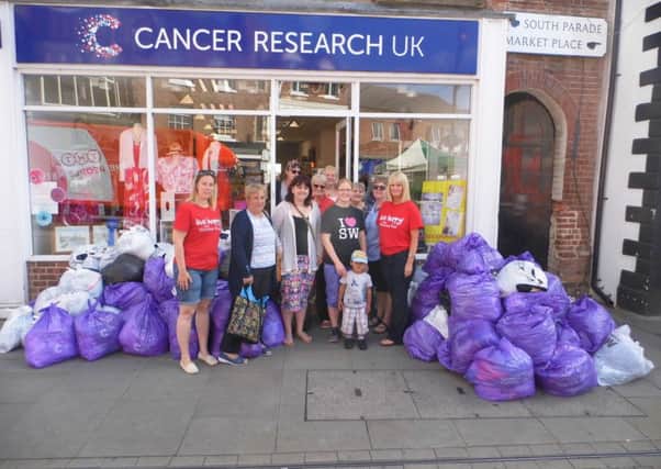 Melton Slimming World members, consultants and Cancer Research UK shop representatives with donated bags of clothes PHOTO: Supplied