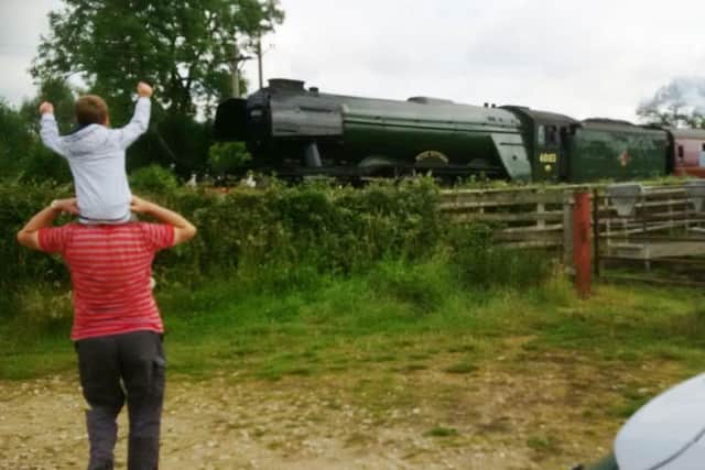 Nick Farrow's photo of his grandson excitedly watching the Flying Scotsman passing through Frisby EMN-170307-121617001