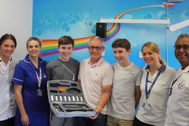 Nigel Roberts and his twin sons, James and Oliver, hand over the new spirometer to staff at Glenfield Hospital EMN-170307-154904001