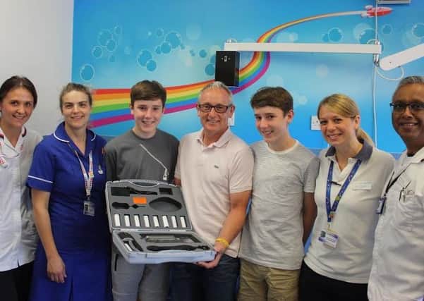 Nigel Roberts and his twin sons, James and Oliver, hand over the new spirometer to staff at Glenfield Hospital EMN-170307-154904001