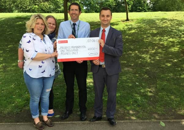 Stuart Northedge, head teacher at Frisby Primary School receives a cheque for £1,000 from Leon Elford, branch manager at Santander PHOTO: Supplied