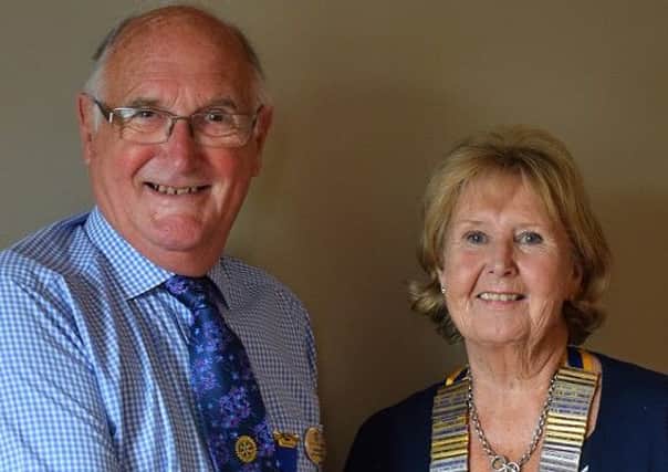 Outgoing president of Melton Mowbray Rotary Club Ian Neale hands over the chain of office to his successor Janet Shortland PHOTO: Supplied