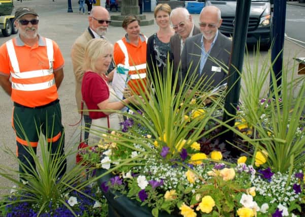 Members of Melton in Bloom, Melton Bid and the East Midlands in Bloom judges look at one of the themed planters in Market Place, Melton EMN-170507-114543001
