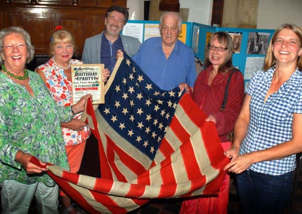 Members of Hickling History Group and distant relatives of Fred Maltby Warner, who left the village in the 1800s and became a US governor, holding a 100-year-old US flag gifted to them EMN-170718-144902001