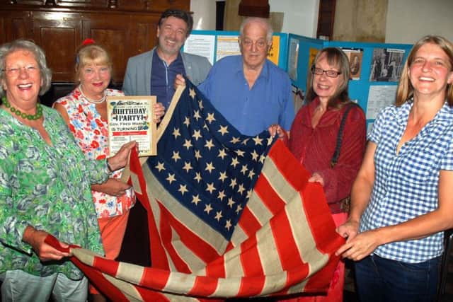 Members of Hickling History Group and distant relatives of Fred Maltby Warner, who left the village in the 1800s and became a US governor, holding a 100-year-old US flag gifted to them EMN-170718-144902001