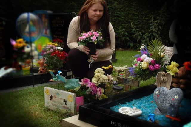 Pauline Hutchinson at the grave of her premature daughter, Sunshine, in the Thorpe Road cemetery in Melton, with the neighbouring grave close by to the right EMN-170724-140020001