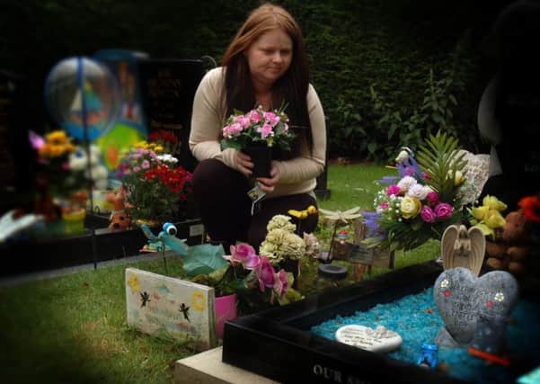 Pauline Hutchinson at the grave of her premature daughter, Sunshine, in the Thorpe Road cemetery in Melton, with the neighbouring grave close by to the right EMN-170724-140020001