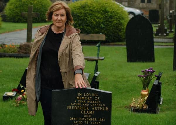 Jennifer Hughes by her father's gravestone in Melton's Thorpe Road cemetery - her car is visible in the background where it was parked when someone smashed the window to steal her handbag EMN-170808-133041001