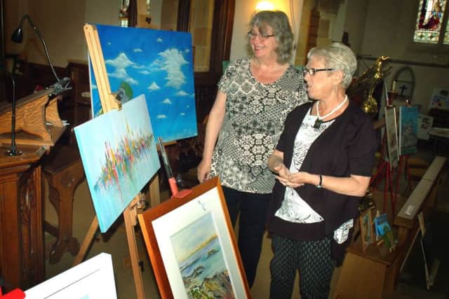 Organiser Gill Stubbs takes Sandie Williamson for a tour of the exhibition PHOTO: Tim Williams