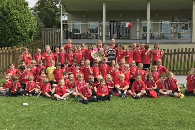 Mrs Boylan is given flowers and presented with a signed Leicester Tigers rugby shirt by the children of Waltham on the Wolds Primary School PHOTO: Supplied