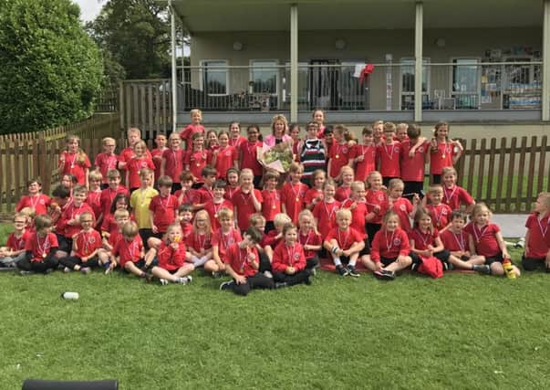 Mrs Boylan is given flowers and presented with a signed Leicester Tigers rugby shirt by the children of Waltham on the Wolds Primary School PHOTO: Supplied