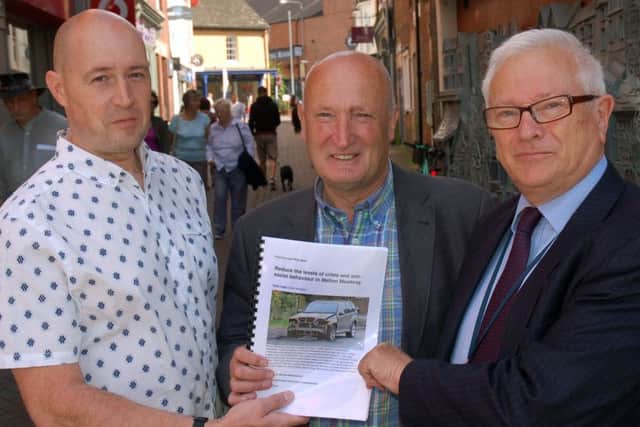 Resident Chris Foster (left) hands over a petition to crime commissioner Lord Willy Bach (right) and Melton Council leader, Councillor Joe Orson, calling for action to tackle the recent upsurge in crime in the town EMN-170815-160608001