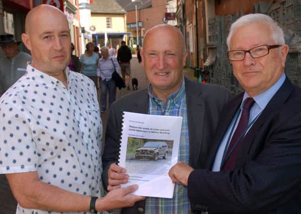 Resident Chris Foster (left) hands over a petition to crime commissioner Lord Willy Bach (right) and Melton Council leader, Councillor Joe Orson, calling for action to tackle the recent upsurge in crime in the town EMN-170815-160608001