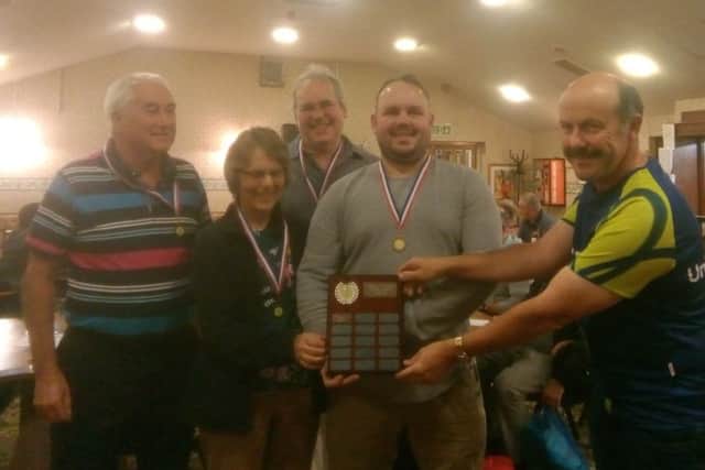 Alan Pakenham-Walsh, Judy, Ed and Stephen Smithers receive the winners shield from quizmaster Richard Angrave PHOTO: Supplied