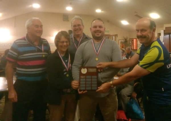Alan Pakenham-Walsh, Judy, Ed and Stephen Smithers receive the winners shield from quizmaster Richard Angrave PHOTO: Supplied