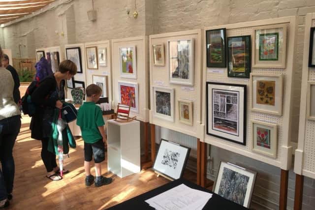 Interested spectators young and old browse round the art exhibition PHOTO: Supplied