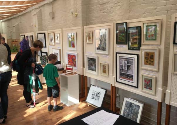 Interested spectators young and old browse round the art exhibition PHOTO: Supplied