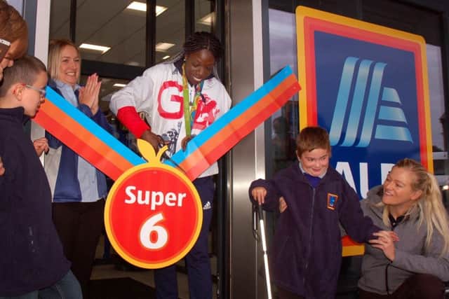 Olympic athlete Anyika Onuora cuts the ribbon at the opening of the new Melton Aldi stores, with pupils from the town's Birchwood School helping EMN-170915-105236001