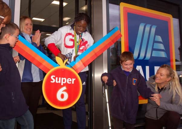 Olympic athlete Anyika Onuora cuts the ribbon at the opening of the new Melton Aldi stores, with pupils from the town's Birchwood School helping EMN-170915-105236001