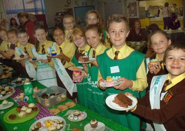 St Francis school pupils line up with lots of tempting treats at their Macmillan morning which raised Â£479 PHOTO: Tim Williams